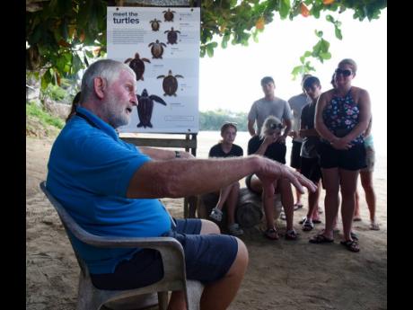Melvyn ‘Turtleman’ Tennant (left), Melyvn Tennant, founder of the Oracabessa Bay sea turtle project at Gibraltar Beach in Oracabessa, St Mary, educates tourists on the value of helping to save the turtle species in Jamaica, during a turtle release at t