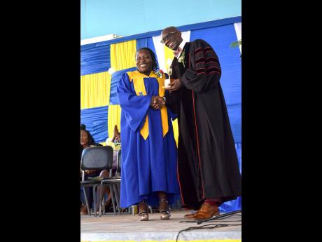 Gabriel Harriett who earned nine subjects in the CSEC examinations receives her Top Girl award from Principal Dr. Oneil Ankle at the Jonathan Grant High School’s graduation ceremony recently.