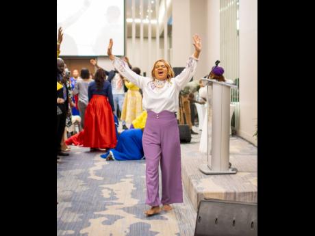 Rev Marie Berbick lifts her arms in worship at the Repositioned International Women’s Conference.