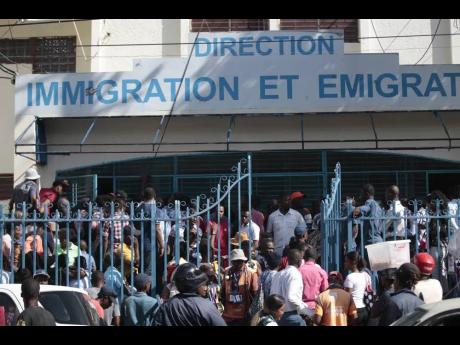 In this January photo Haitians are seen lining up outside an immigration office as they wait their turn to apply for a passport in Port-au-Prince.