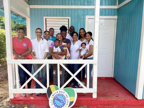 Annette Thompson and her family share a photo op with Michelle Henry and her family and members of the charity organisation, Food For The Poor Jamaica.