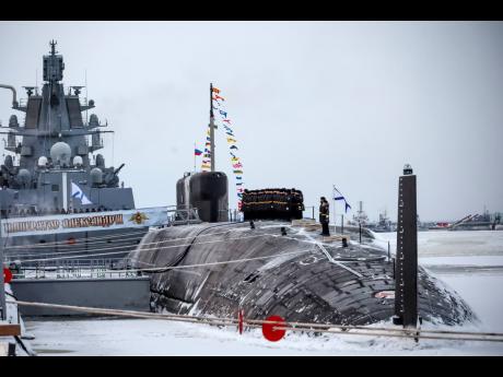 Russian sailors stand on deck of the newly-built nuclear submarine ‘The Emperor Alexander III’ as Russian President Vladimir Putin attends a flag-raising ceremony for newly-built nuclear submarines at the Sevmash shipyard in Severodvinsk, Russia on Mon