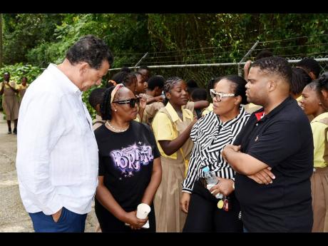 Violet Brown (second left), grandmother of slain student Randino James, is being consoled by St James Southern Member of Parliament Homer Davis (left) as she speaks with Anchovy High Principal Lavern Stewart (second right) and Renardo Douglas, vice chairma