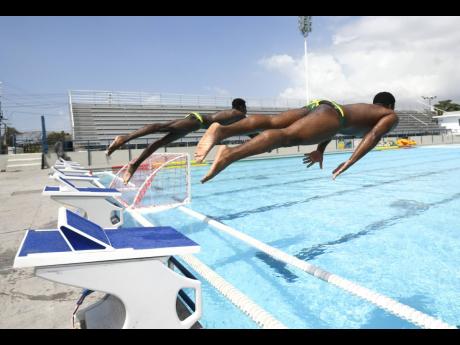 Boys dive into the pool at the National Aquatic Centre in Kingston.
