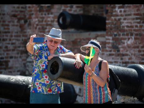 Visitors Gordon (left) and Penny Eaton pose by one of the canons at the entrance of Fort Charles as they and scores of other tourists explored Port Royal in 2020.