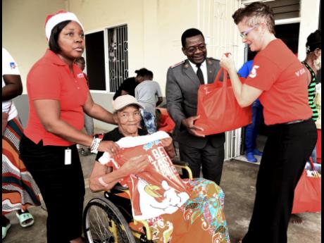 Major Nana Boakye-Agyemang (second right), divisional commander, Salvation Army Eastern Jamaica Division, is assisted by Debra Lopez Spence (right), director of Scotiabank Foundation, and Claudine Murray (left), relationship manager, Scotiabank, in handing