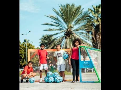 Youngsters participating in the Sandals Foundation Future Goals Programme are pictured here next to football goals created by Limpi Recycling Company. The goals were created using abandoned fishing nets and plastic waste.