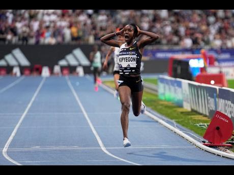 Faith Kipyegon, of Kenya, crosses the finish line to win the Women 5000 metres, setting a new world record during the Meeting de Paris Diamond League athletics meet in Paris on Friday, June 9, 2023. 