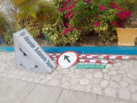 The sign that used to point to the Sir Alexander Bustamante Square in Lucea, Hanover, lies on the ground as the National Works Agency embark upon a traffic-flow improvement project in the Hanover capital. Several people have expressed concerns about the si