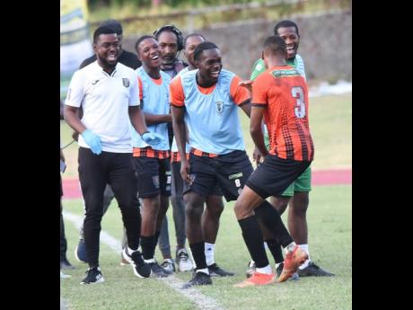 Odean Pennycooke (right) of Tivoli Gardens FC celebrates with his teammates after scoring a 72nd minute  winner against Molynes United during their  Wray and Nephew Jamaica Premier League match at the Stadium East field yesterday.