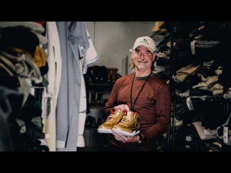 James Free poses for a photo with a pair of of gold Nike AirJordan 3 sneakers at the Portland Rescue Mission on  October 30, in Portland, Ore. The sneakers, designed in 2019 for filmmaker Spike Lee, that were donated to the homeless shelter, sold for nearl