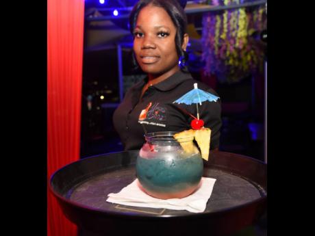 Waitress Ashley Richards proudly introduces the blue Hawaiian punch from the selection at Haus of Booze.