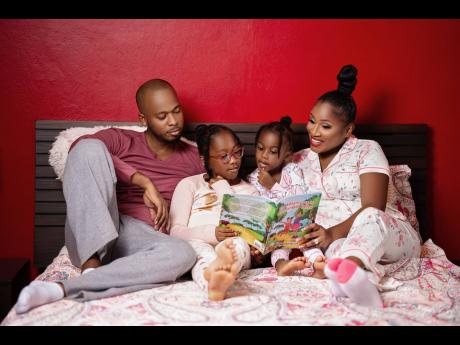 Children’s book author Basillia Barnaby-Cuff is joined by her husband, Brian, and daughters Bree’Ah-Marie (second left) and Bella-Renée as they read her book during some quality bedtime reading as a family. 