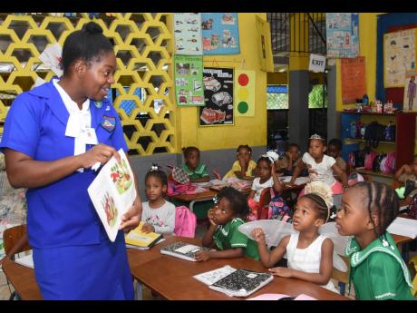 Arlene White-Crewe from Sam Sharpe Teachers’ College engages students of the Montego Bay Infant School as she reads to them on Read Across Jamaica Day.