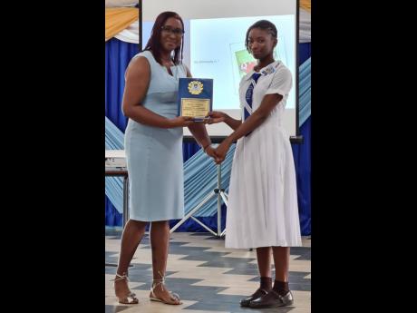 Lisa Vassel (left), a past student, hands top student Michaela Lawrence one of her many awards at the Marymount High School’s recent prizegiving.