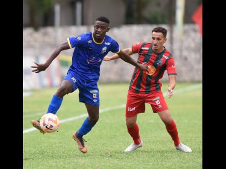 Molynes United’s Sujae McBean (left) moves the ball away from Montego Bay United’s Jean Claudio Rios Ferreira during their Wray and Nephew Jamaica Premier League football match at the Anthony Spaulding Sports Complex on Wednesday.