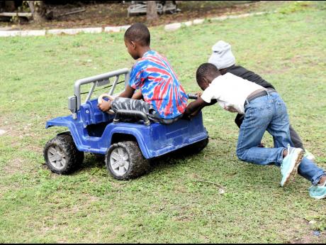 Children from the City of Refuge Children’s Home in Content Gap, St Andrew, play with a toy car during a Christmas treat sponsored by 138 Student Living for children and staff of Jamaica National Children’s Home. The treat was held at the Jamaica Natio