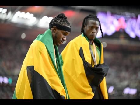 Silver medallist Wayne Pinnock (left) and bronze medallist Tajay Gayle of Jamaica, draped in their flags at the 2023 World Athletics Championships at the National Athletics Centre in Budapest, Hungary on August 24.  