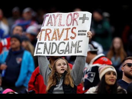 A fan displays a sign that calls attention to Taylor Swift and Kansas City Chiefs tight end Travis Kelce during the second half of an NFL game between the Chiefs and the New England Patriots on December 17, 2023, in Foxborough.