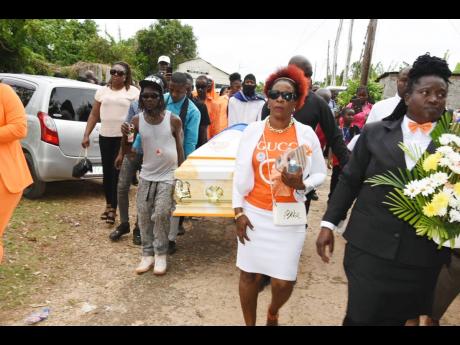 Members of People’s National Party activist and entrepreneur Janet Thompson’s family carry the coffin bearing her body towards her final resting place in McAlpine, Westmoreland.