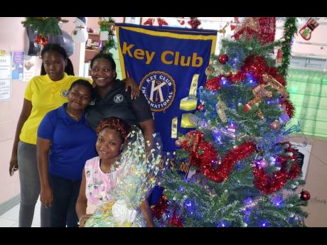 Terece Hyatt (right), mother of newborn Aladane Samuels, the first baby to be born at the Savanna-la-Mar Public General Hospital in Westmoreland yesterday, holds a gift basket presented by members of The Manning’s School’s Key Club. The Key Club has be