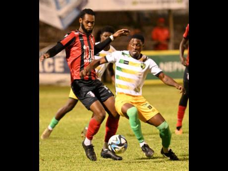 Jahvon James (left) of Arnett Gardens and Tavar Thompson of Treasure Beach battle for the ball during last night’s Jamaica Premier League match at the Anthony Spaulding Sports Complex. Arnett won 2-0 with goals from Fabian Reid and Rushike Kelson. 