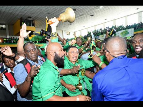 
Prime Minister Andrew Holness (centre) arrives with his bell at the JLP 80th Anniversary Conference at the National Arena in Kingston in November 2023.