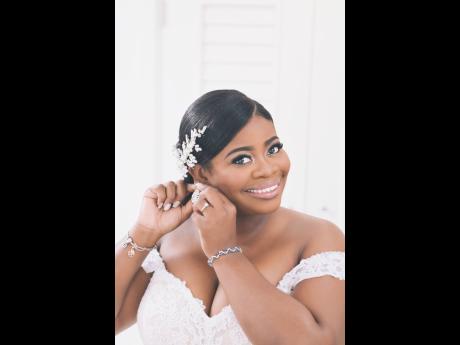 A vision of beauty and elegance, Latara Boodie Stevens was elated to walk up the aisle in this gorgeous fit and flare wedding dress, boasting an off-the-shoulder sweetheart neckline and floral details.