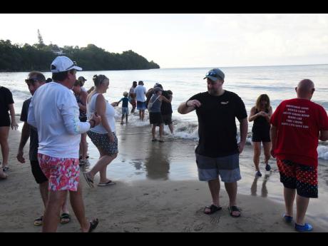 Tourists staying at Sandals Properties in St Ann help to wash debris from baby turtles before releasing them into the sea at Gibraltar Beach in St Mary last month.