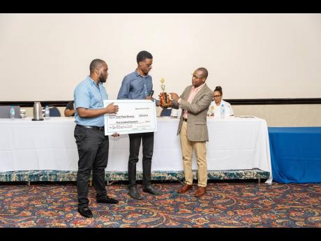Dr. Joel Allen (right), co-founder and executive chairman of Growth Perspectives Limited handing over a trophy and first place prize to winners of the GP Innovate 2023 Innovation competition James Barrett (centre) and Michael Small of team I-Learn from the