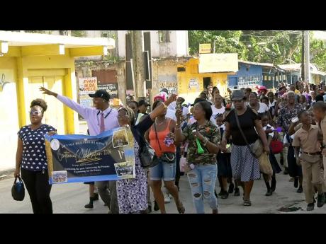 Principal of Grange Hill Primary School, Clayton Smith (second left) leading students, teachers, and parents in a road march as part of the school’s 100th anniversary celebrations on Monday, January 15.
