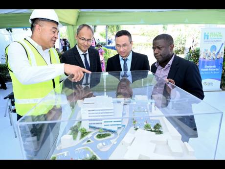 Rudolph Brown/Photographer
Dr Christopher Tufton (left), minister of health and wellness, examines a model of the hospital renovation with (from second left) Biao Ding, manager of Jiangsu Zhenhai Construction Limited; Gang Li, project manager of Jiangsu Zh