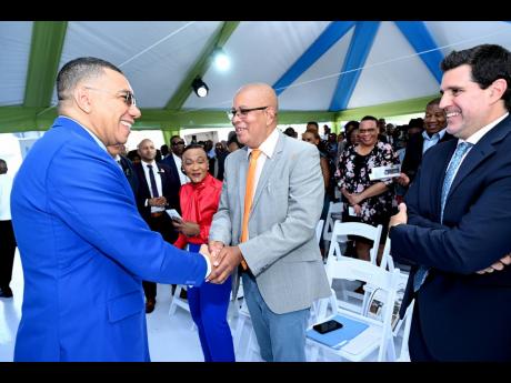 Prime Minister Andrew Holness (left), greets Councillor Norman Scott (centre), mayor of Spanish Town, while Denise Daley (second left), member of parliament for St Catherine Eastern and Lorenzo Escondeur, chief of operations of Inter-American Development B