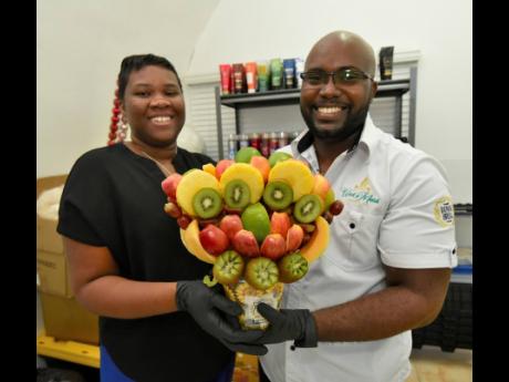 Brittney (left) and Paul Romelus pose with a recently created edible arrangement. 
