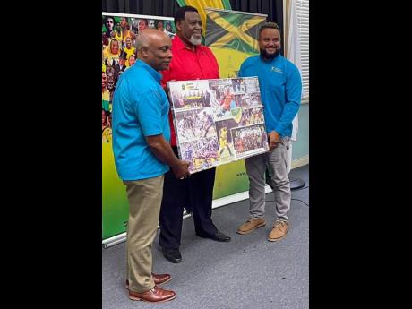 Jamaica Hockey Federation President Fabian Stewart (centre) presents a collage of photographs of members of the Hockey5s World Cup team to Jamaica Olympic Association (JOA) President Christopher Samuda (left) and General Secretary and CEO Ryan Foster on De