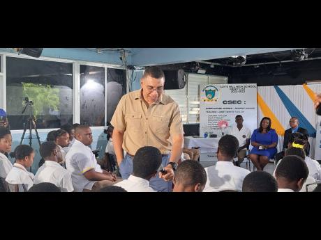 Prime Minister Andrew Holness speaks with fifth and sixth-formers at Guy’s Hill High School in St Catherine. 