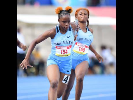 Edwin Allen High’s Tia Clayton (left) is off and running on the final leg of the Class One 4x100m at the 2022  ISSA/GraceKennedy Boys and Girls’ Championships at the National Stadium.