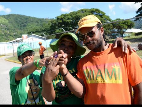 PNP and JLP supporters pose for a photo after they cast their vote in the 2016 local government elections. 