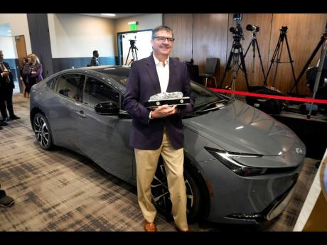 Scott Neiheisel, Toyota North America, stands with the Toyota Prius winning the 2024 North American Car of the Year award.