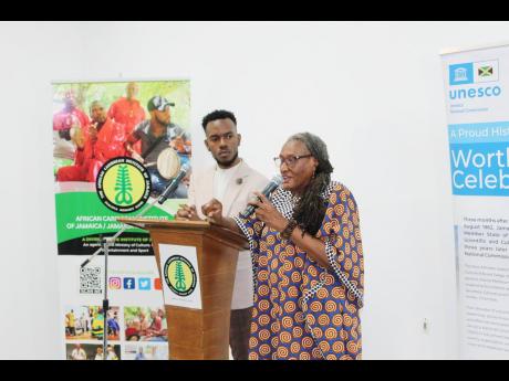 Revival research/scholar Dr Maria A. Robinson-Smith addressing the gathering during the launch of  ‘Journeying Revival Iconography’, on Friday, December 15, 2023. At left, Dr Kirt Henry, director at ACIJ/JMB, fellow Revival researcher/scholar, and prac
