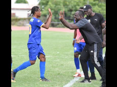 Tyrique Wilson (left) of Molynes United celebrates with coach Jermaine Thomas (right) after scoring his team’s second goal against Humble Lion during their Jamaica Premier League football match at the Stadium East field yesterday.  Molynes United won 3-2