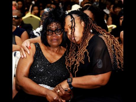 Naomi Hendricks (left), widow of the late tourism mogul Robert Hendricks, and daughter Marvia Hendricks comfort each other during Robert Hendricks’ funeral  at the Montego Bay Convention Centre on Sunday, January 28.