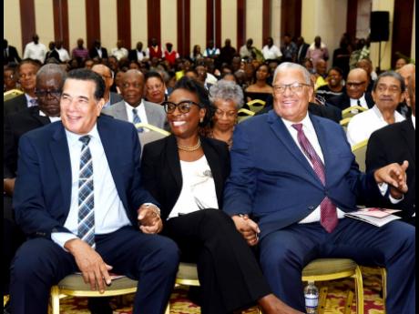 From left: Homer Davis, state minister in the Office of the Prime Minister in the West; Senator Janice Allen, opposition spokesperson on tourism; Dr Peter Phillips, former opposition leader, hold hands during the funeral for the late tourism mogul Robert H