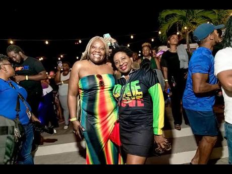 Reggae fans Delrose Miller-Brown left of Mastercard, Canada and Montego Bay businesswoman, Janet Silvera represent for the culture in their Rasta colours.