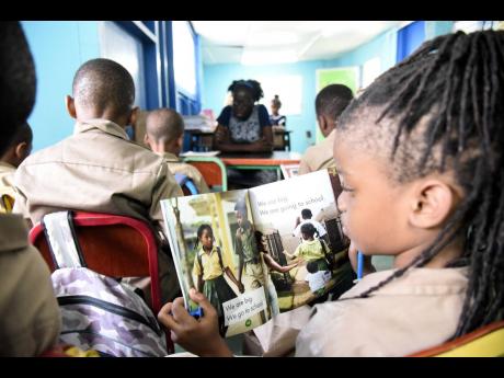 Students at Grove Primary and Infant School in St Andrew delve into a book during a ‘Drop Everything and Read’ session last week.