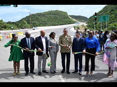 Prime Minister Andrew Holness (fifth left) and other officials cut the ribbon to officially open the Harbour View to Yallahs Bridge section of the Southern Coastal Highway Improvement Project on Tuesday. Joining in the occasion are (from left) St Thomas Ea