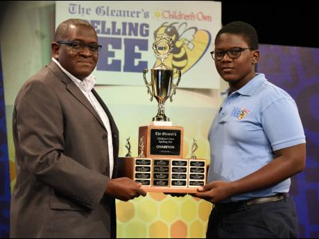 Ian Allen
Anthony Smith (left), CEO of the RJRGLEANER Communications Group, presents Ashawney Burrell (right) with the Gleaner’s Children’s Own Spelling Bee Trophy shortly after he spelt the championship word ‘M-A-L-A-F-I-D-E’ to win the championsh