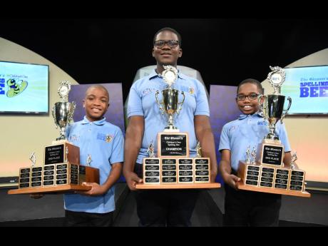  Ashawney Burrell (centre), who attends Campion College and represents St Andrew, is The Gleaner’s Children’s Own Spelling Bee champion after he spelt the championship word ‘M-A-L-A-F-I-D-E’ to win the championship for 2024.  He is flanked by Danie