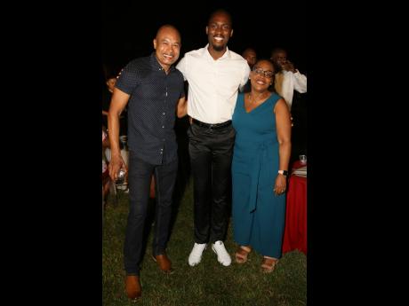 Jamaican track and field athlete, Hansle Parchment, is flanked by Steven Chen (left), export manager for Grace Foods LACA and Grace Burnett, chief executive officer, GraceKennedy Financial Group.