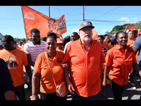 Mark Golding (centre), Opposition leader and president of the People’s National Party (PNP), speaks with the media while PNP councillors, Louise Newland (left), for the Admiral Town division and Sarah Marshall (right), for the Trench Town division, flank